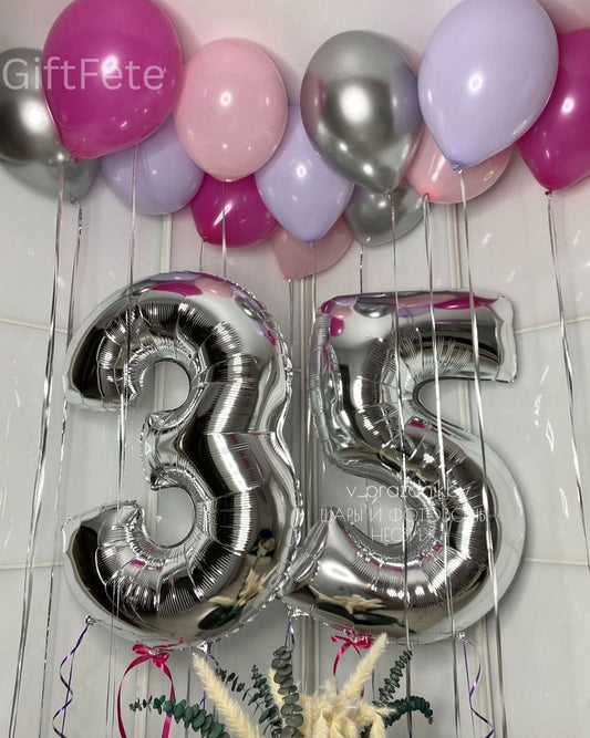 Silver number balloons '35' with pink, purple, and silver balloons on a tiled wall background.